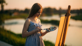 blonde-girl-paints-painting-canvas-outdoors-sunset